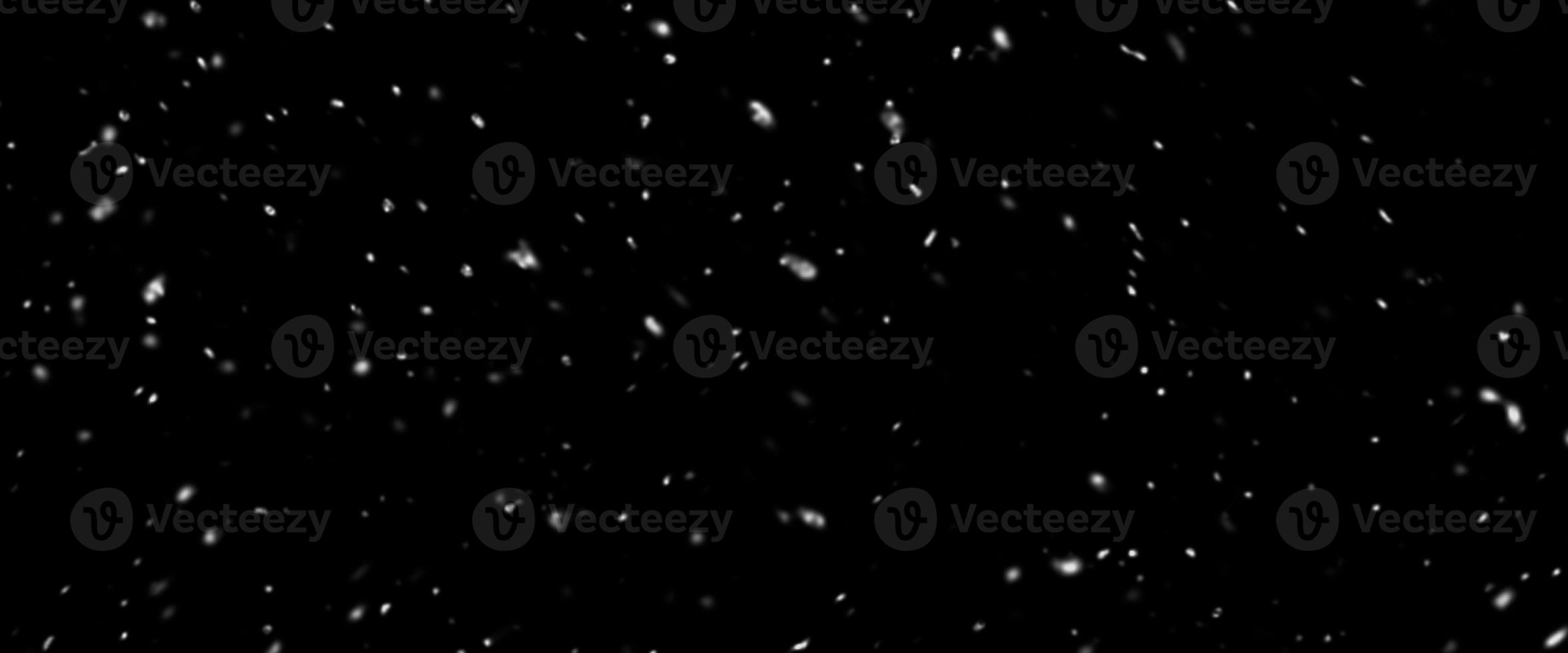 Falling snow isolated on black background. Falling snow at night. Bokeh lights on black background, flying snowflakes in the air. Winter weather photo