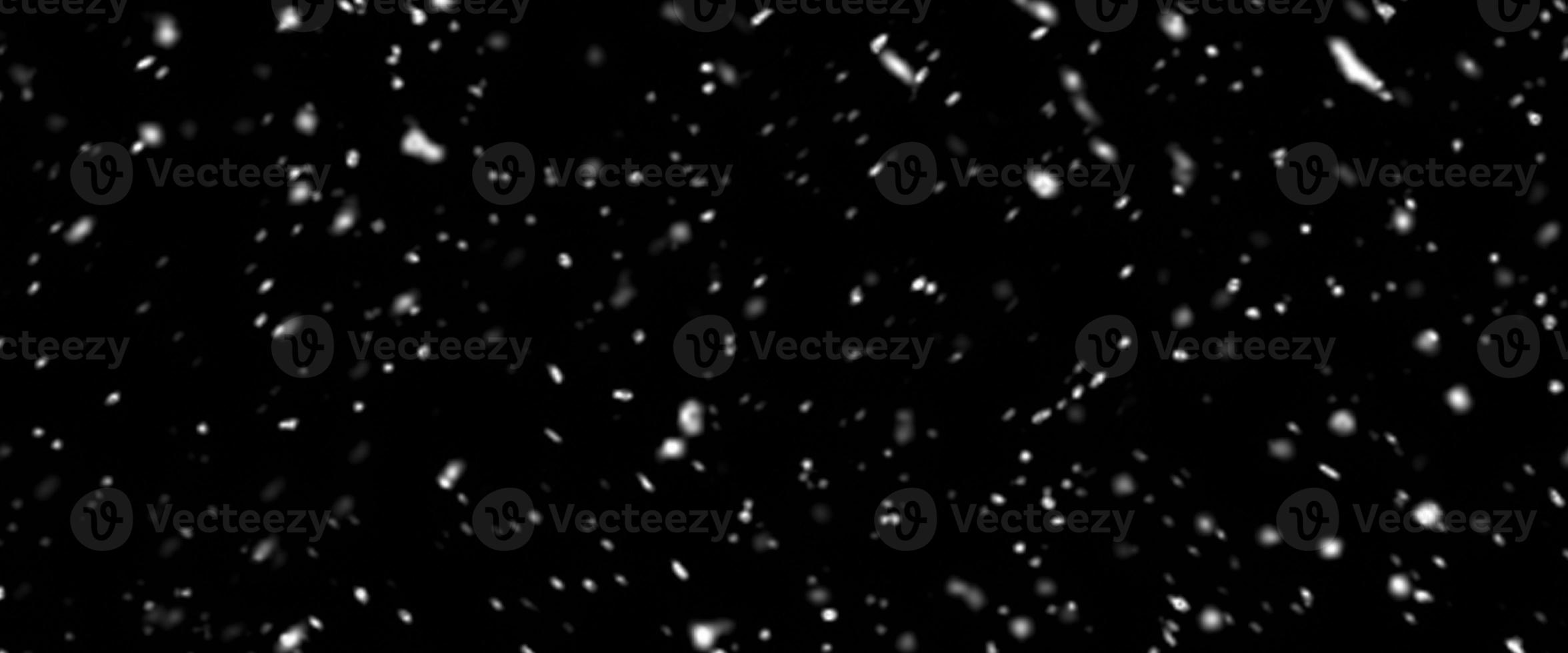 Falling snow isolated on black background. Falling snow at night. Bokeh lights on black background, flying snowflakes in the air. Winter weather. Overlay texture. photo