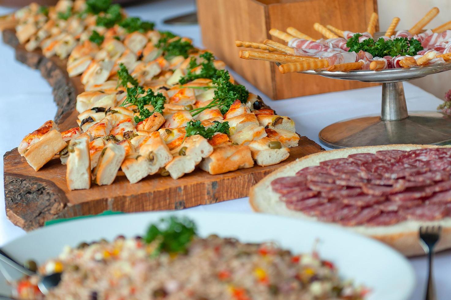 Appetizer of savory pizzas and other salami in a wedding party photo