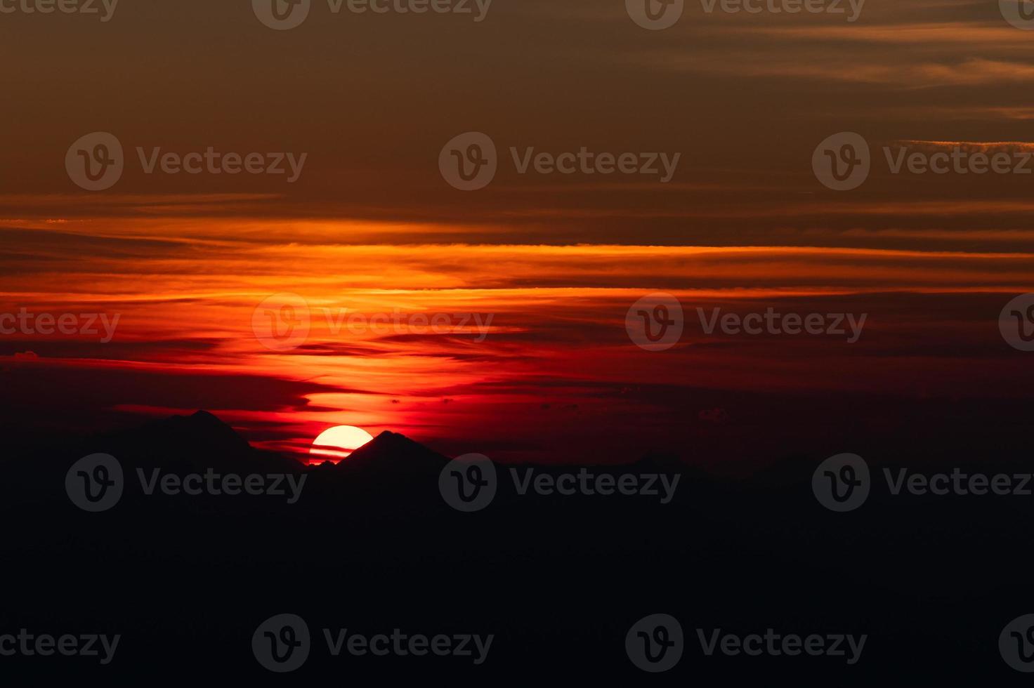 puesta de sol entre las cimas de las montañas en los alpes foto