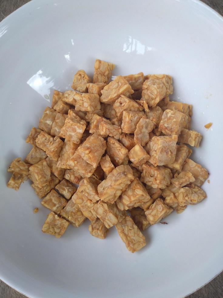Famous Javanese cuisine food , Tempe or Tempeh made of fermentation process that binds soybeans into a cake form, sliced and fried. Famous in Indonesia and Malaysia photo