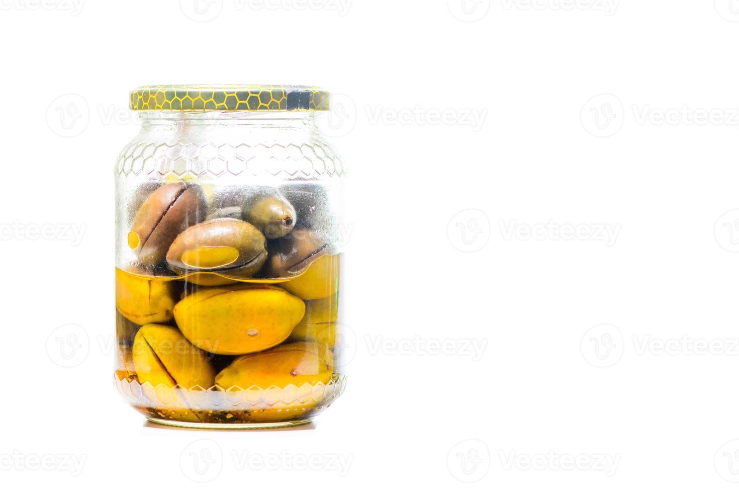 Glass jar with Italian green olives on white background photo