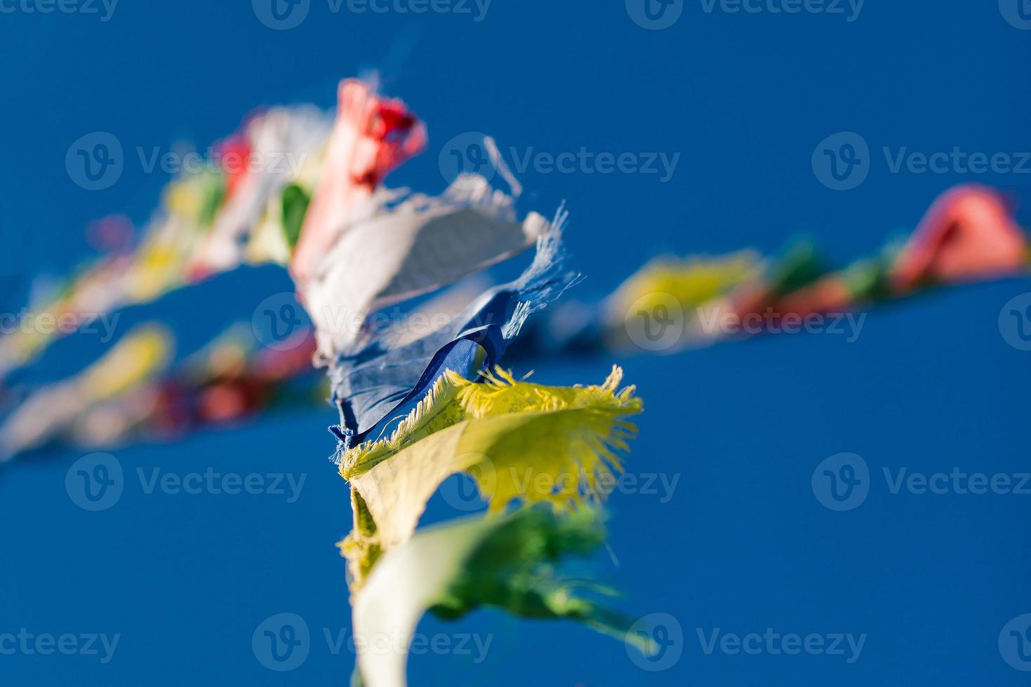 coloridas banderas de oración budista tibetana ondeando en el viento en blu foto