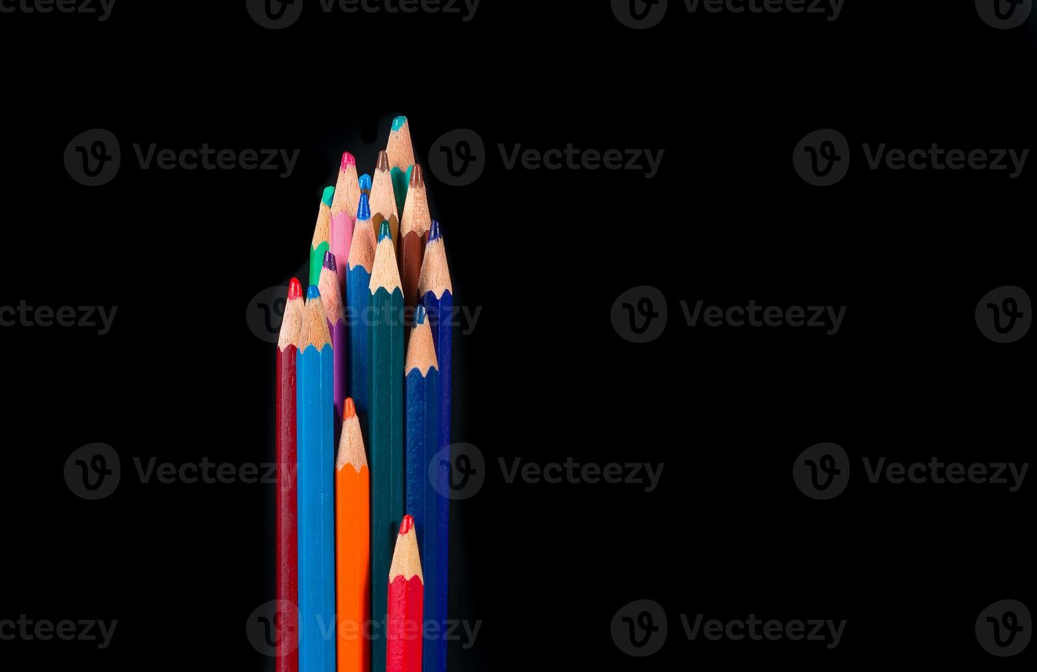 Group of colored wooden pencils on black backgroun photo