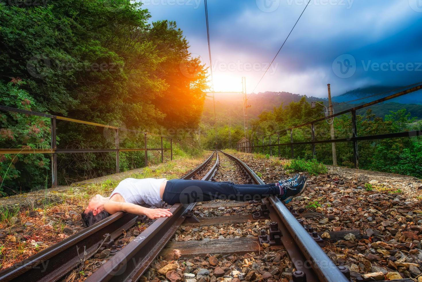 niña acostada en las vías del tren foto