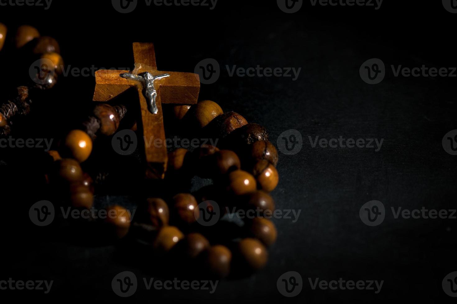 Wreath of the holy wooden rosary on a black background photo