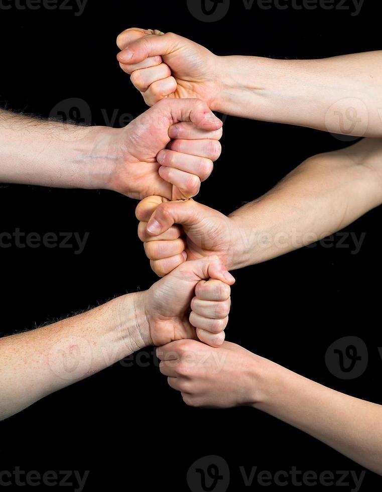 Five fists stacked on each other on a black background photo
