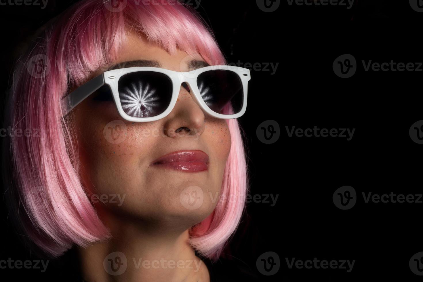 Portrait of girl with studio lights on umbrella reflecting in glasses photo