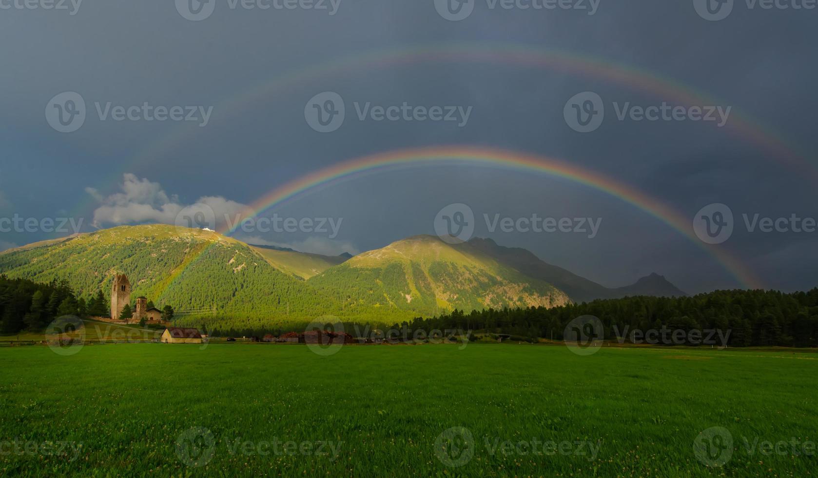 Real full double rainbow in a mountain meadow photo