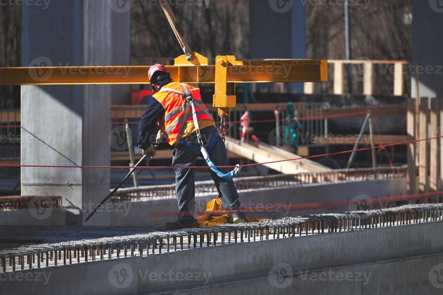 trabajador del sitio de construcción con gancho de arnés de seguridad foto