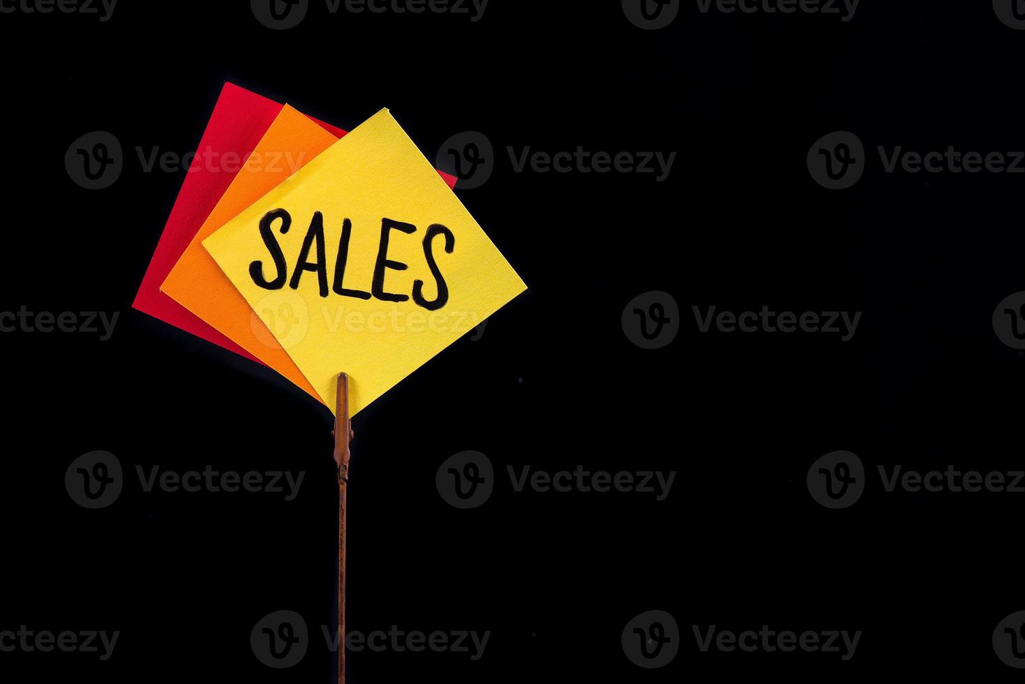 Three slips of colored paper with the word sales. photo