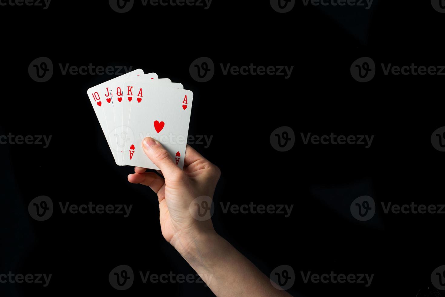 Playing cards in hand isolated on black background photo