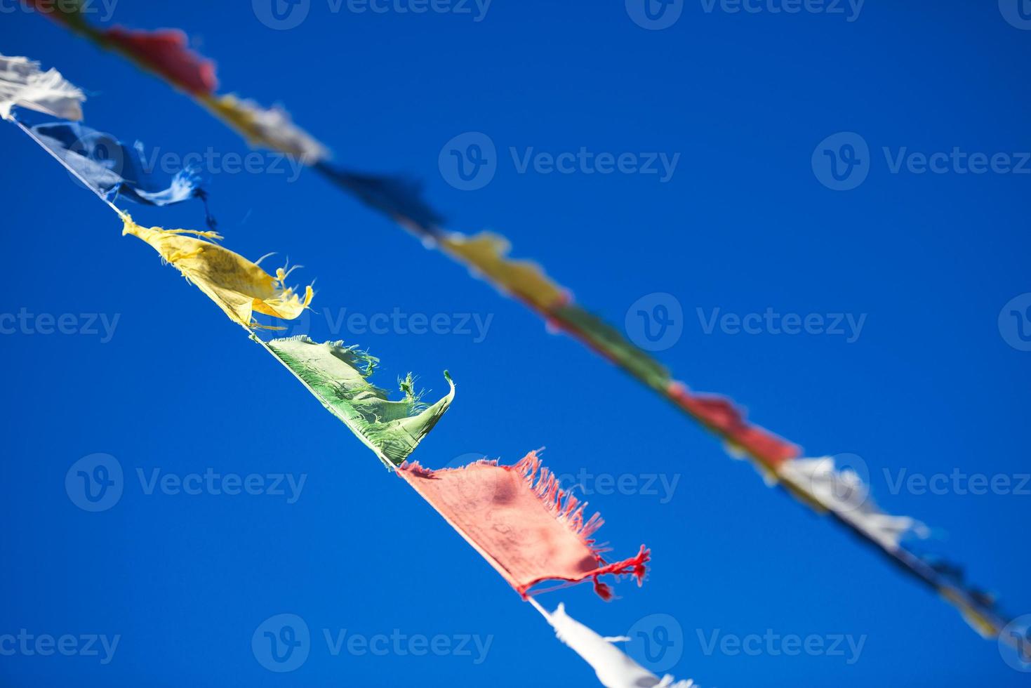 Diagonal hanging vibrant colorful Tibetan Buddhist prayer flags photo