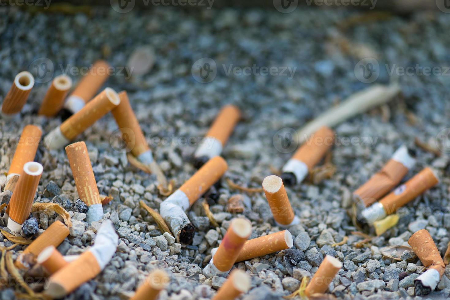 mozzocons de cigarrillos aplastados en la arena foto