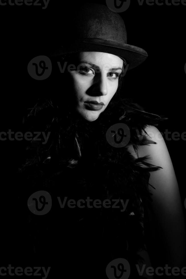 Portrait of woman in bowler hat on black background in black and white photo