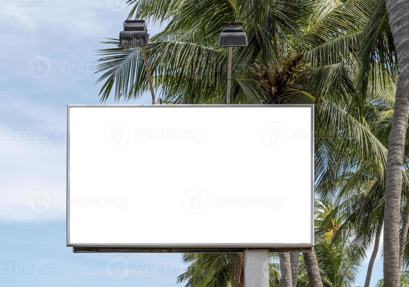 Outdoor pole billboard on coconut tree and blue sky background with mock up white screen and clipping path photo