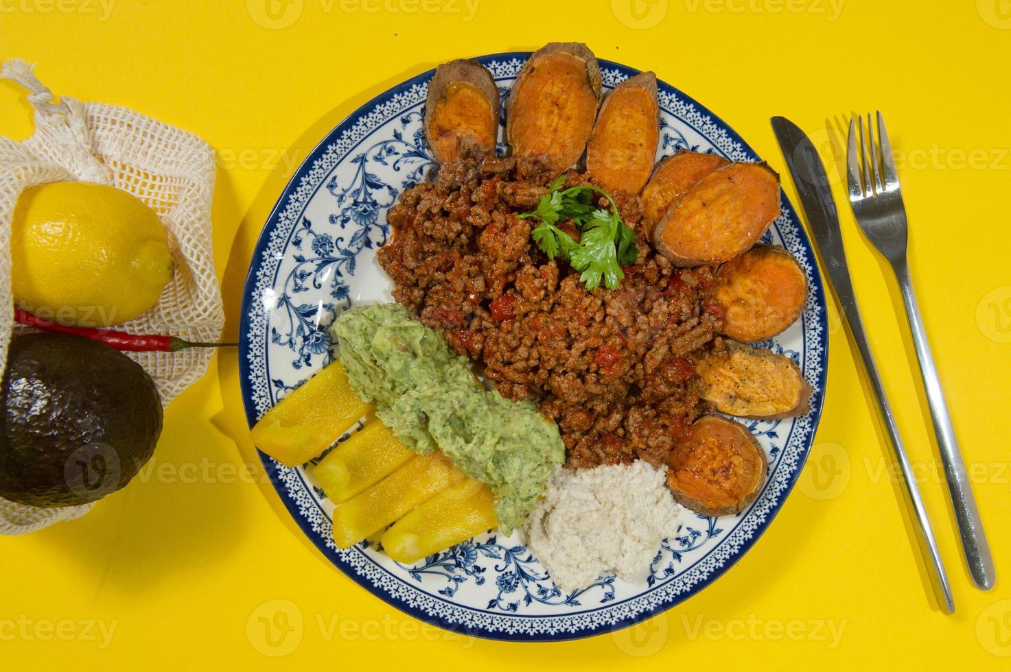 Bean stew with ground beef, sweet potatoes and vegetable served in a rustic cast iron pan on wooden table. Healthy and gluten free meal photo