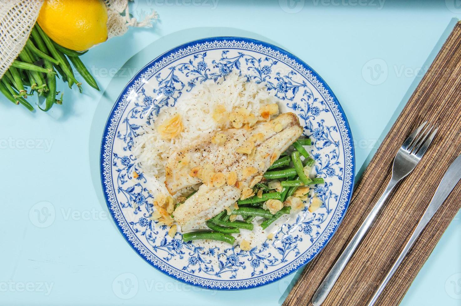 Lebanese-style fried fish on a serving dish with onion flavoured rice and roasted almond slivers. photo
