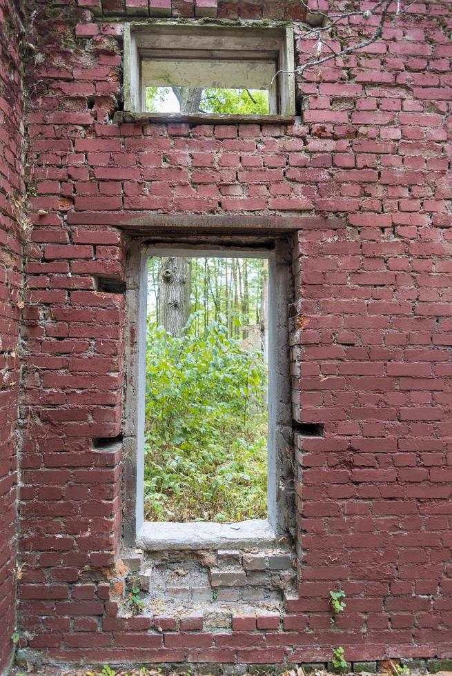 una abertura de ladrillo sin ventana de un edificio antiguo y destruido. foto