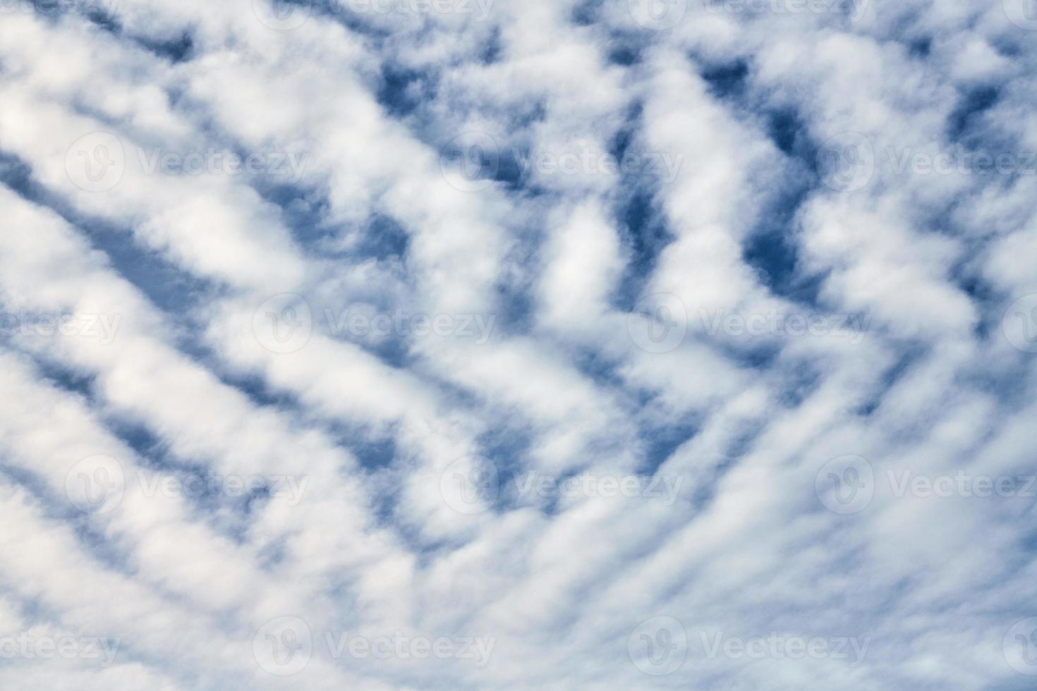 Beautiful blue sky with unusual white Altocumulus undulatus clouds, extraordinary cloud formation photo