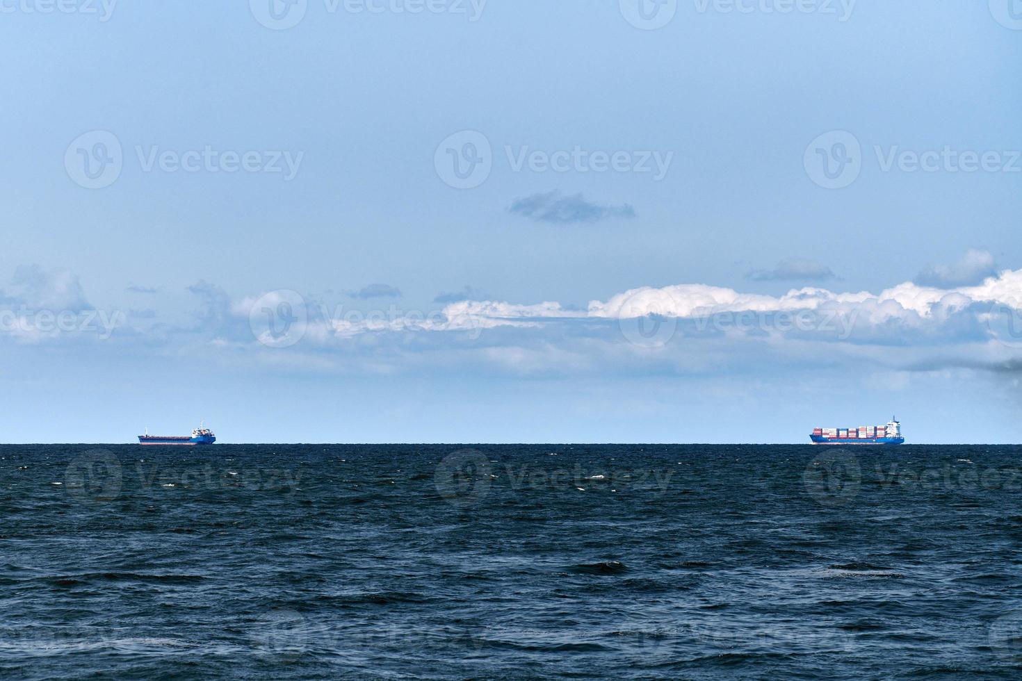 Container cargo ships freighters in distance, import export logistic, cargo ships in blue sea photo