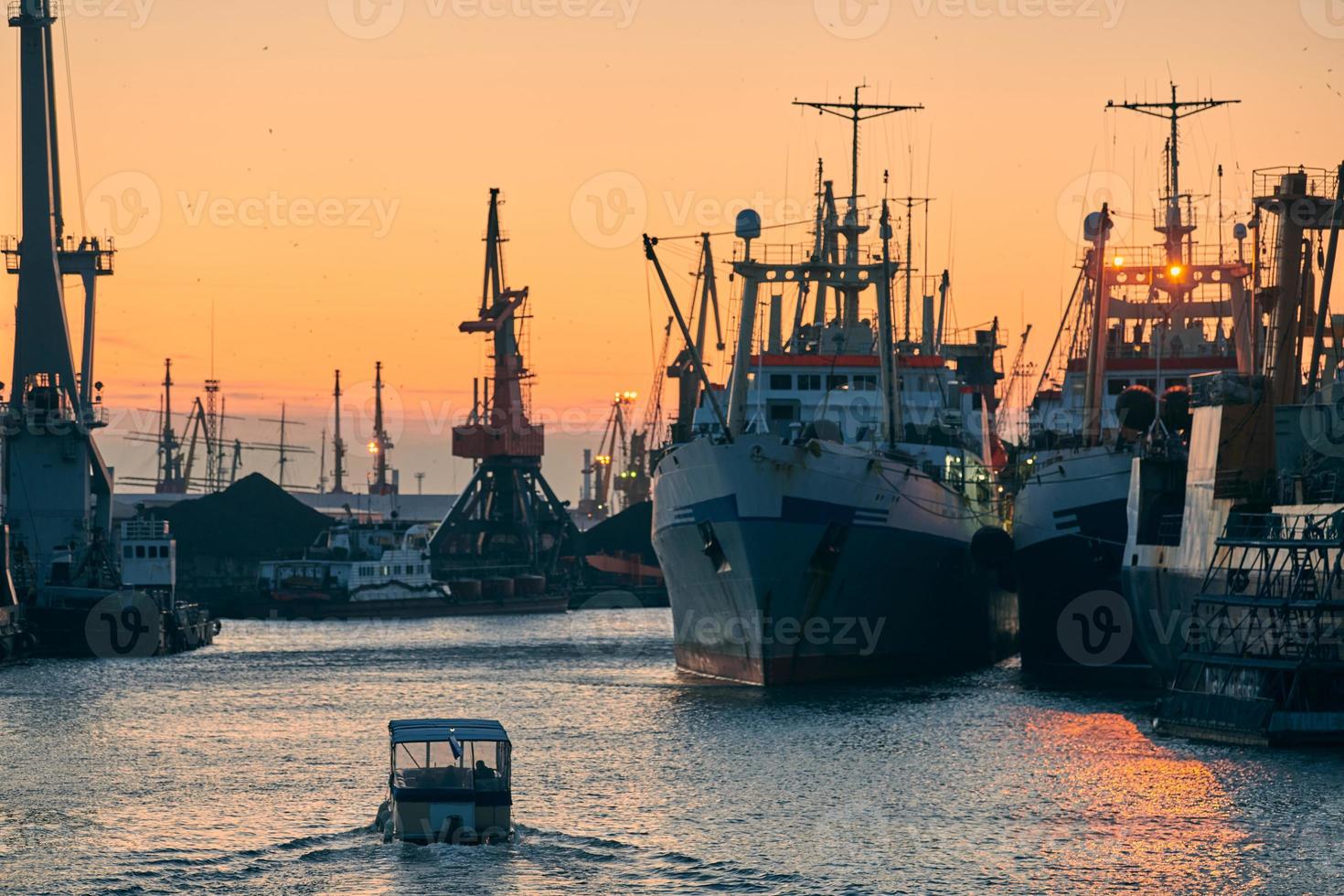 Ships in sea port on sunset background photo