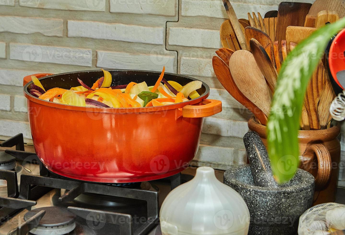 Pieces of tricolor carrots are cooked in saucepan on gas stove photo