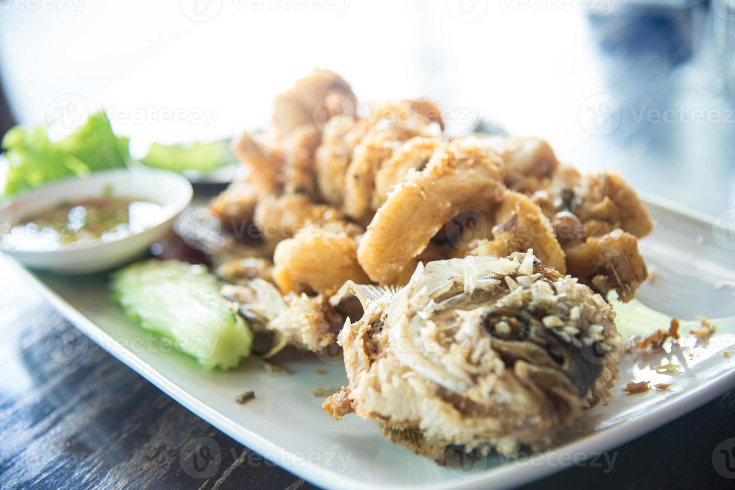 pescado gourami gigante frito con ajo y salsa de marisco, provincia de uthai thani, tailandia foto