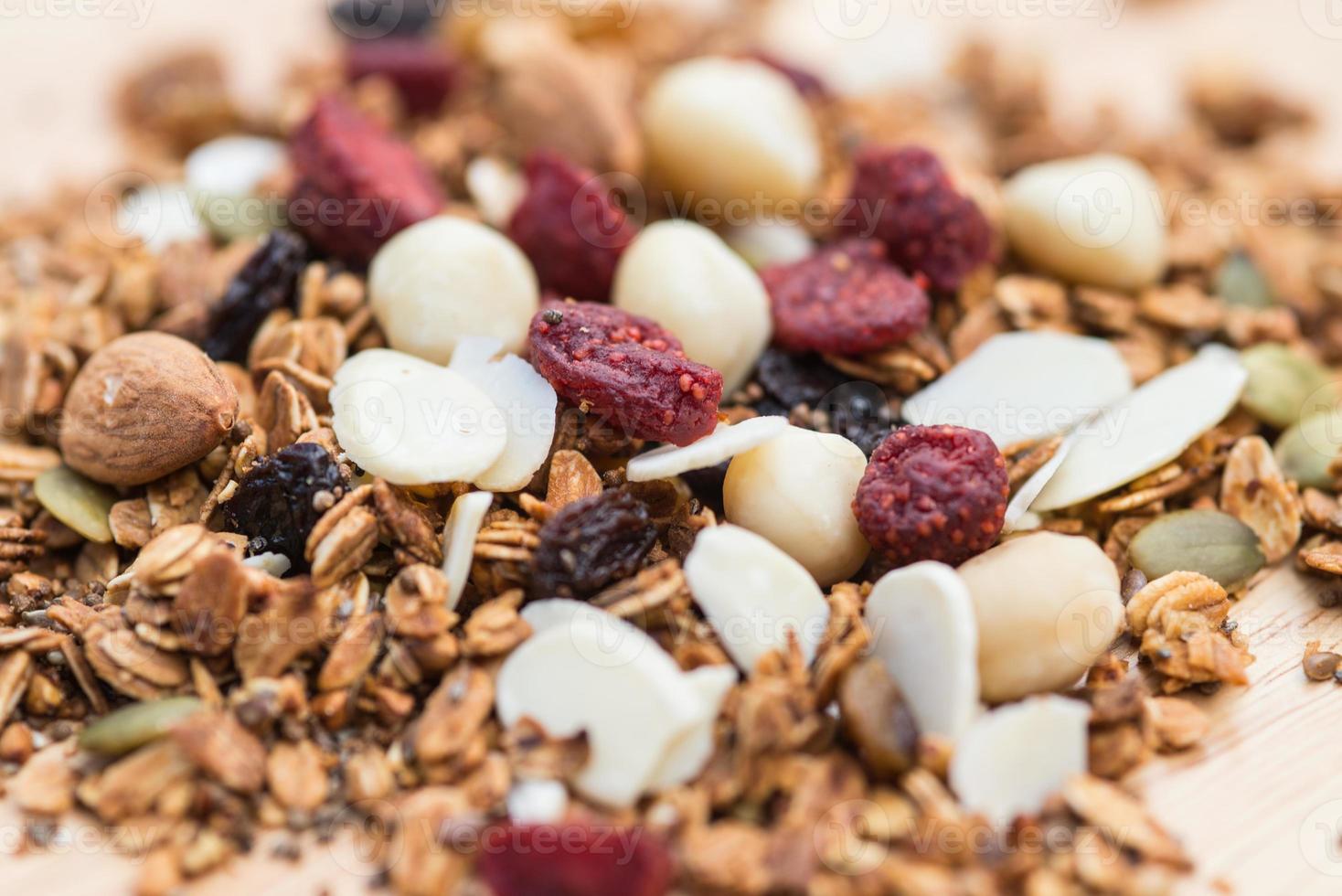 cerrar y desdibujar el desayuno comida saludable, granola, musli, avena orgánica, súper comida con miel, frutos secos y nueces foto