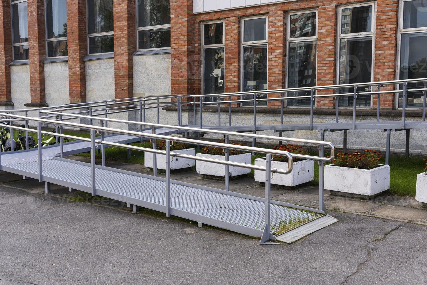 Metal ramp at the entrance to a public building for the disabled photo