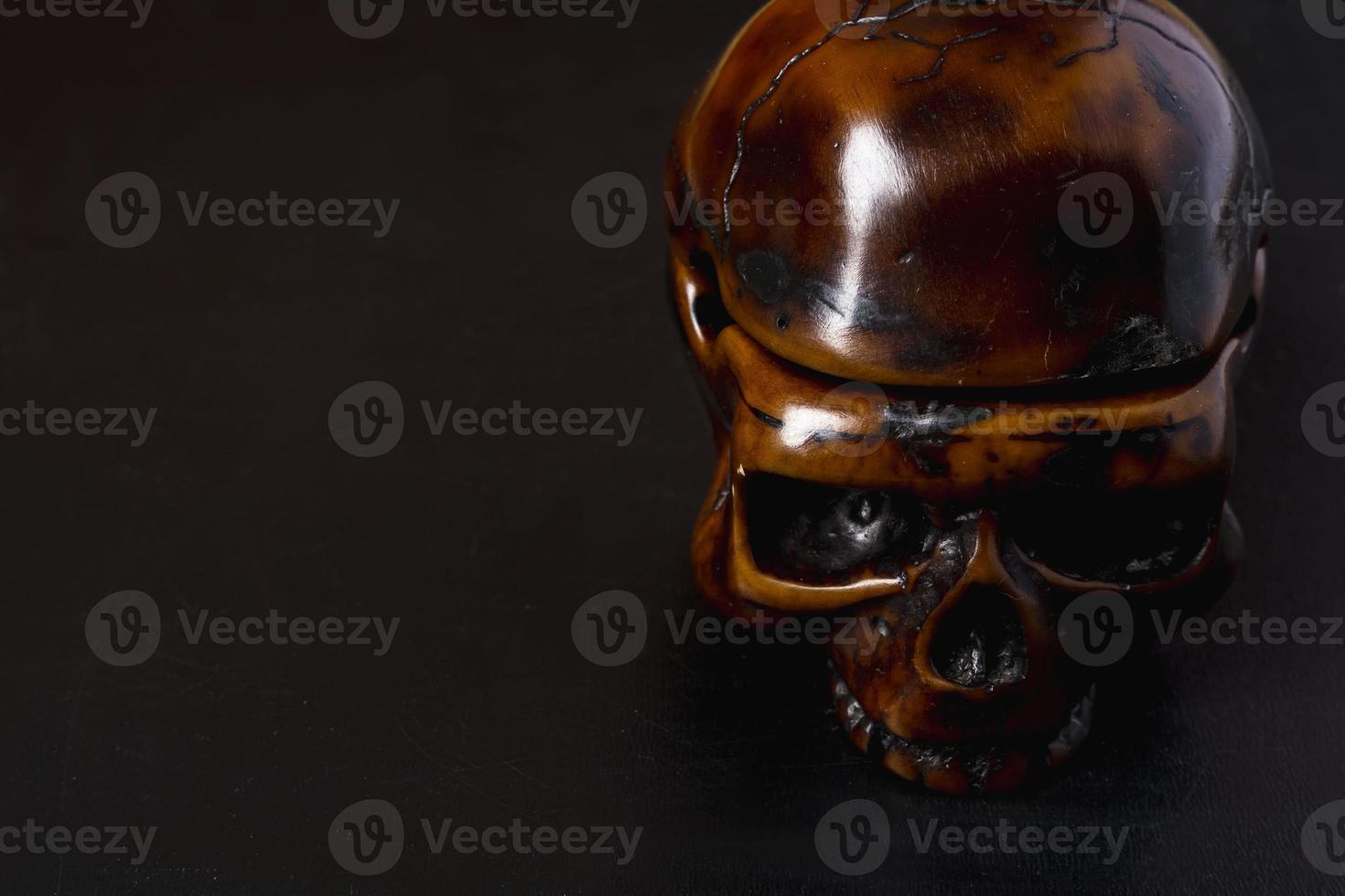 A close-up model of a human skull on a black background, copying space photo