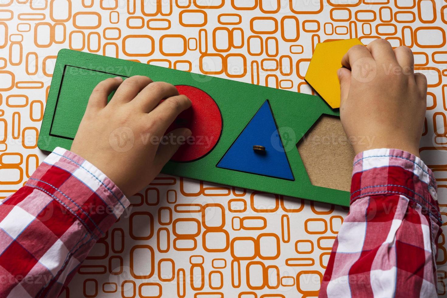 The child collects the sorter constructor. Puzzle sorter, an early development concept. Children's hands put the puzzle photo