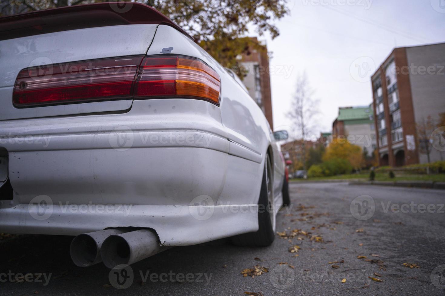 An old classic Japanese car in an autumn urban landscape, popular sedan made in Japan parking on city urban street photo