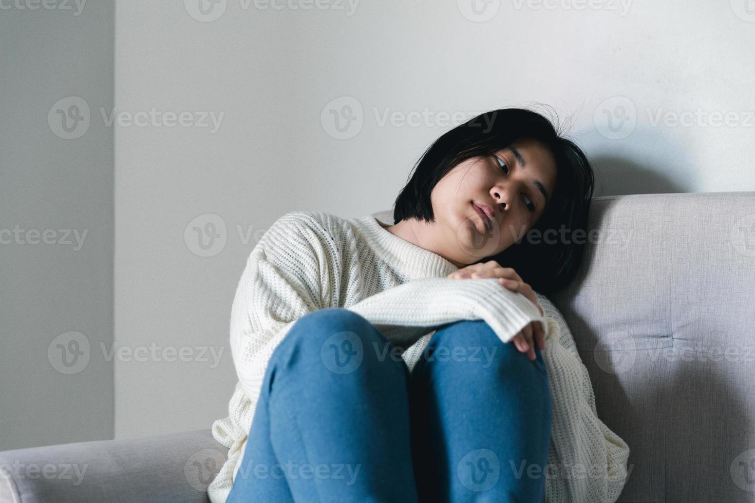 Concept of sad teenage girl depression. Upset teenage girl sitting at window indoors. Anxiety young woman Despair and stress. Lonely and unhappy female are social victims. loneliness youth in home. photo