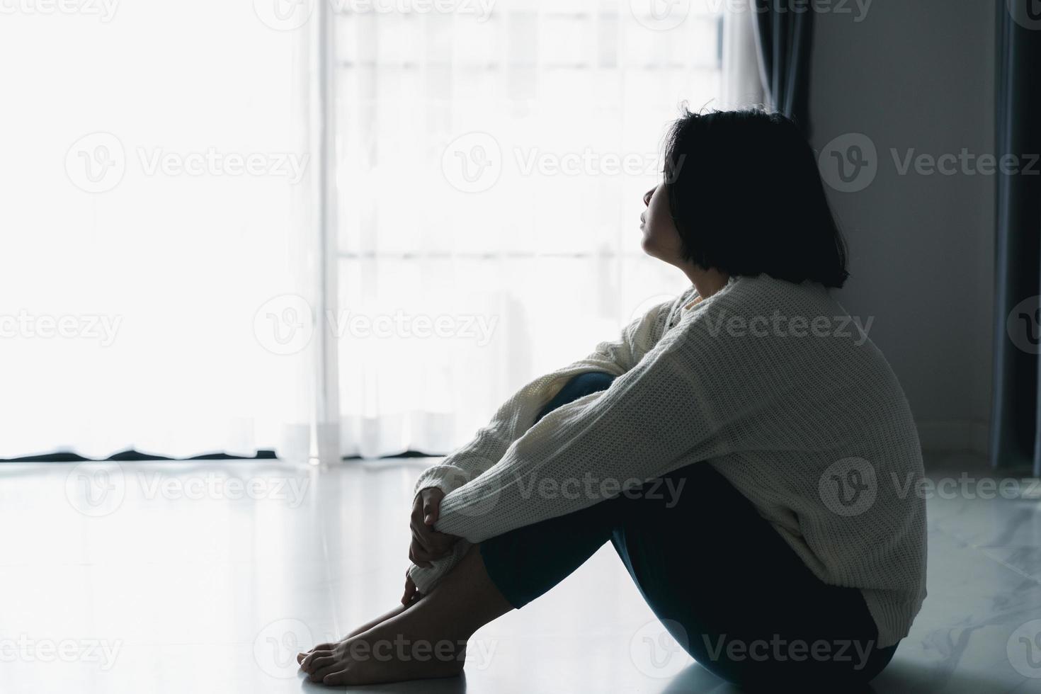 concepto de depresión adolescente triste. molesta a una adolescente sentada en el suelo en el interior. ansiedad mujer joven desesperación y estrés. las mujeres solitarias e infelices son víctimas sociales. juventud de la soledad en casa. foto