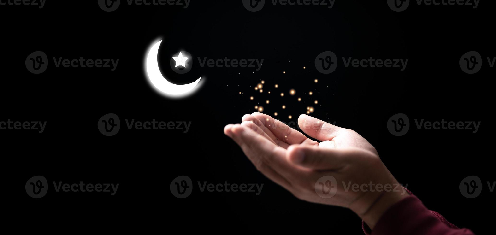 Muslim hand man pray in dark with moon sky background, Male worship to god with faith and belief in black, Arab muslim male person praying for Allah's blessing with hope. concept religion islam. photo