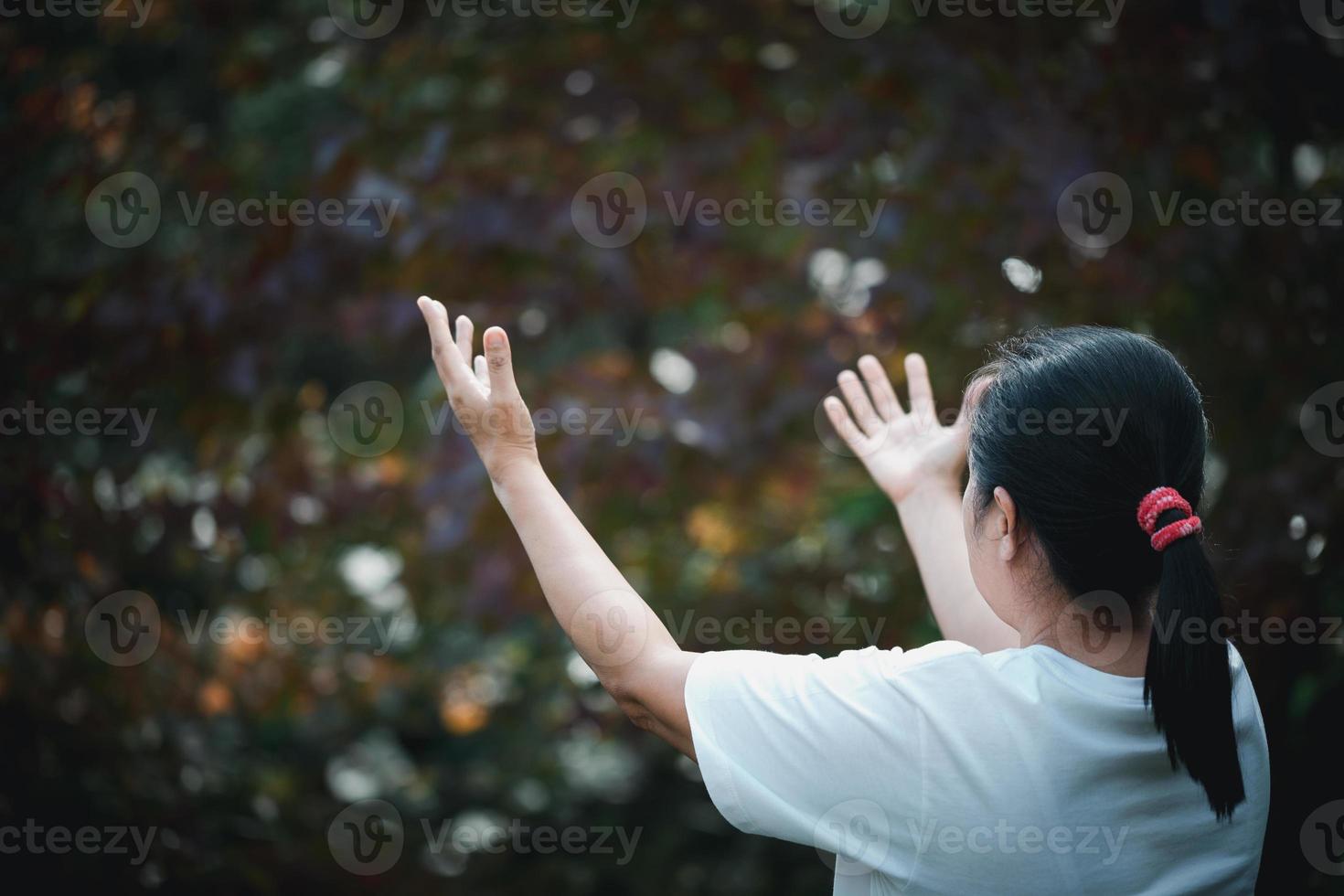 Christ religion and christianity worship or pray concept. Christian catholic woman are praying to god in dark with bokeh. Prayer person hand in nature background. Girl believe and faith in jesus photo