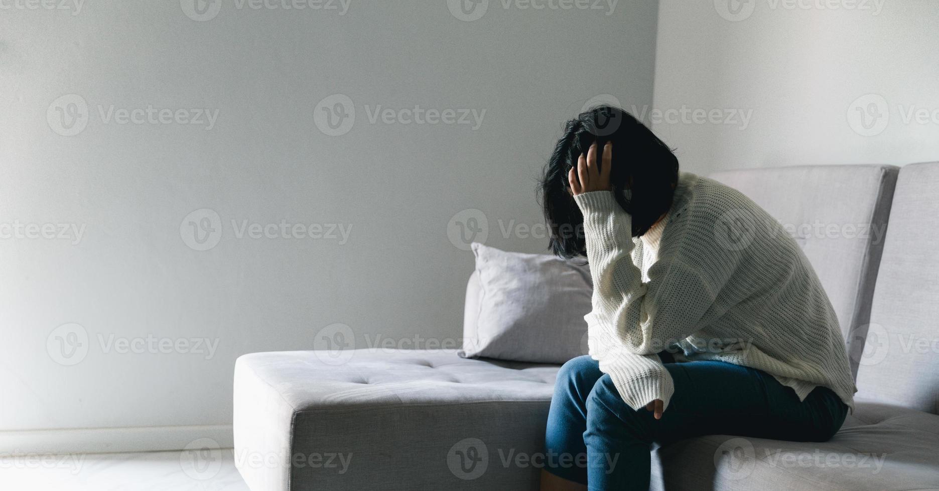Concept of sad teenage girl depression. Upset teenage girl sitting at window indoors. Anxiety young woman Despair and stress. Lonely and unhappy female are social victims. loneliness youth in home. photo