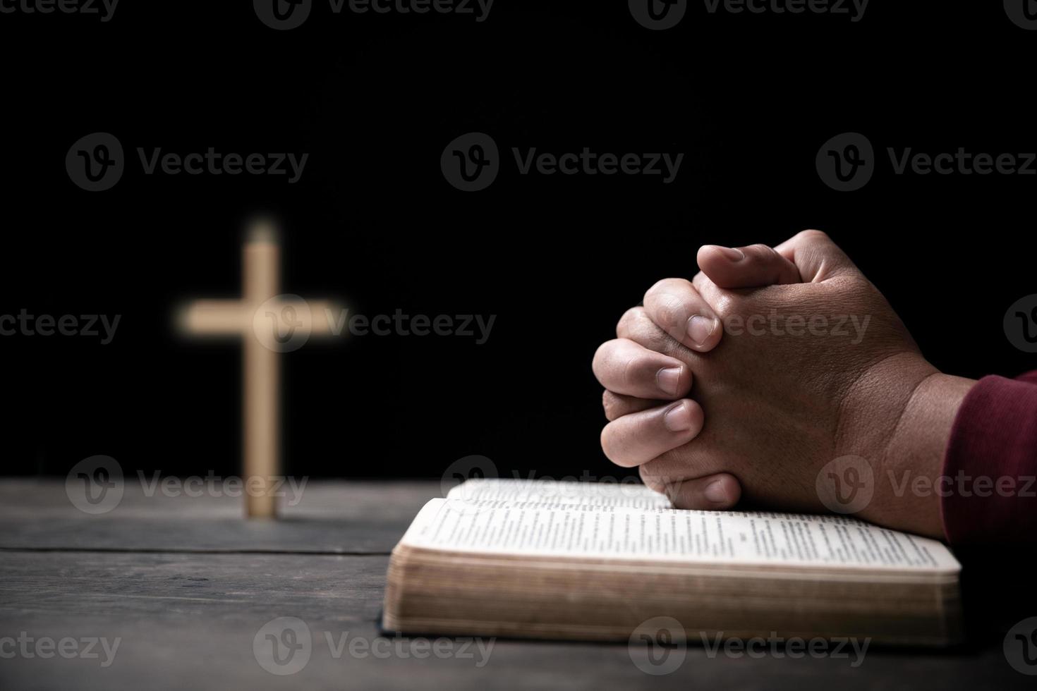Hands folded in prayer on Holy Bible with cross in church concept for faith, spirituality and religion, Man praying on holy bible withcrucifix in morning. Man hand with Bible and rood praying to god. photo
