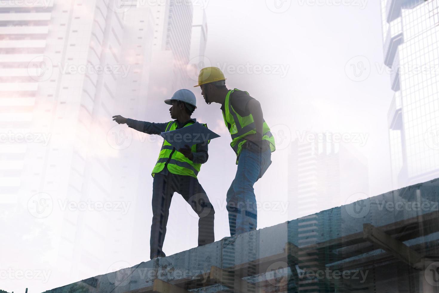 imagen de doble exposición de ingeniero civil y trabajador de la construcción con casco de seguridad y dibujo de construcción contra el fondo de un sitio de construcción surrealista en la ciudad nocturna o el paisaje urbano oscuro. foto