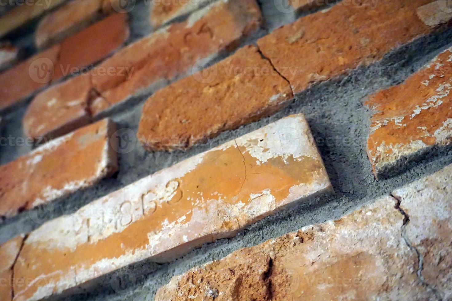 Vintage, Cracked Bricks with Letters on a Wall photo