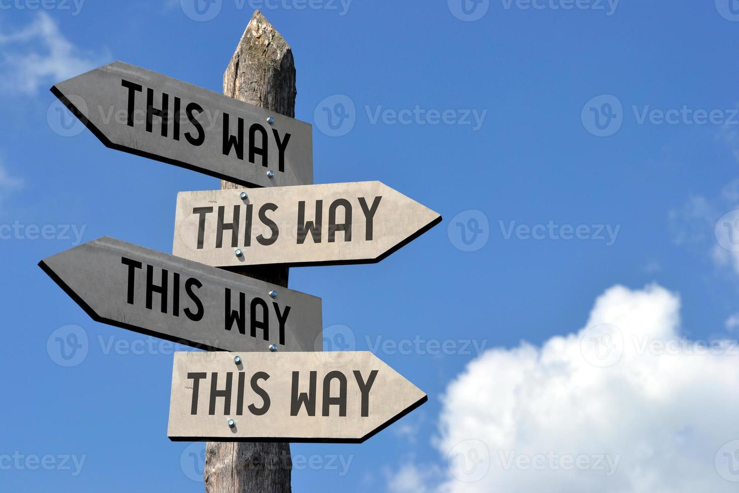 This Way - Wooden Signpost with Four Arrows photo