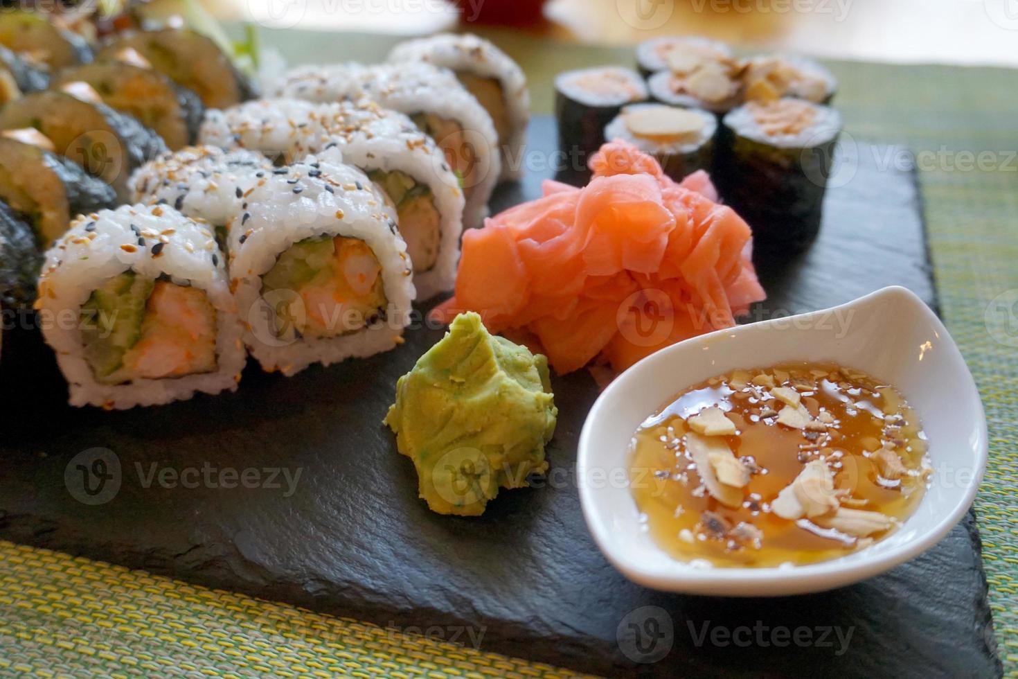 rollos de sushi de salmón en rodajas con jengibre, wasabi y salsa de miel foto