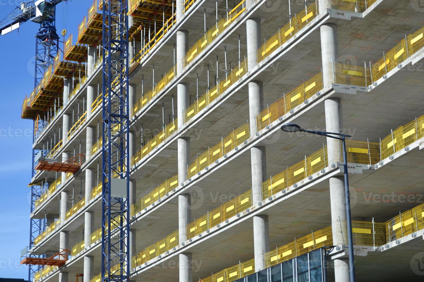 Construction of Multistorey Office Building with Concrete Support Pillars and Cranes photo