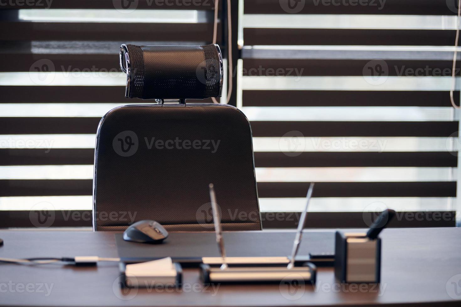 Business office workplace. Work place for chief, boss or other employees. Table and comfortable chair. Light through the half open blinds photo