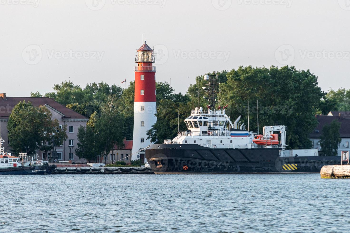 Lighthouse in seaport. Beautiful russian Baltiysk beacon. Clean blue sky. photo