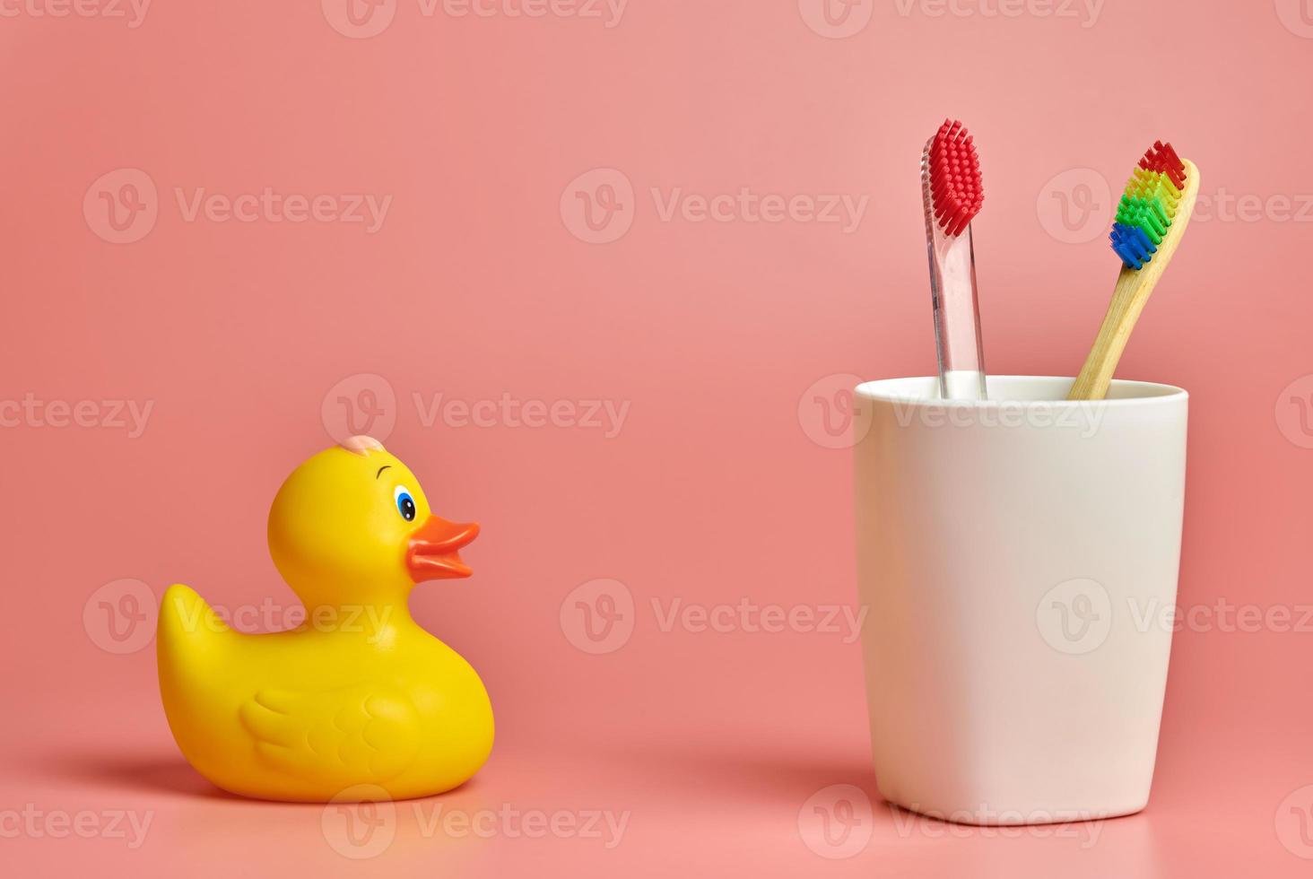 dos cepillos de dientes y juguetes de pato, espacio para copiar. herramienta de cuidado personal para proteger la cavidad bucal, eliminar la placa y el sarro. foto