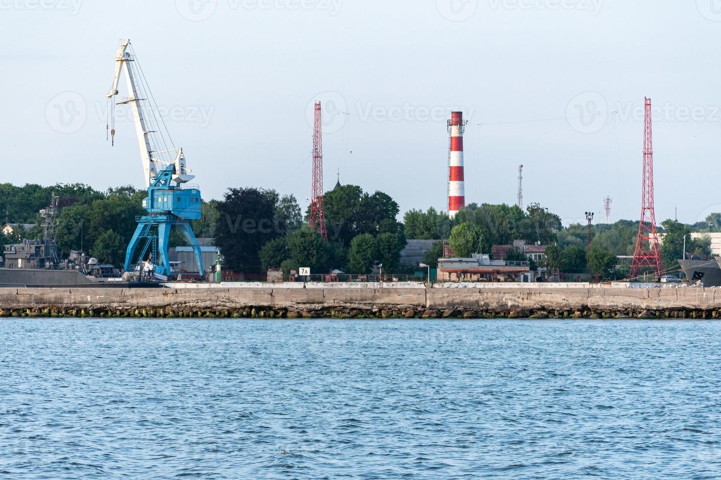 Big crane in dockyard. Large iron navy ships in shipyard for repair. Blue sea harbor photo