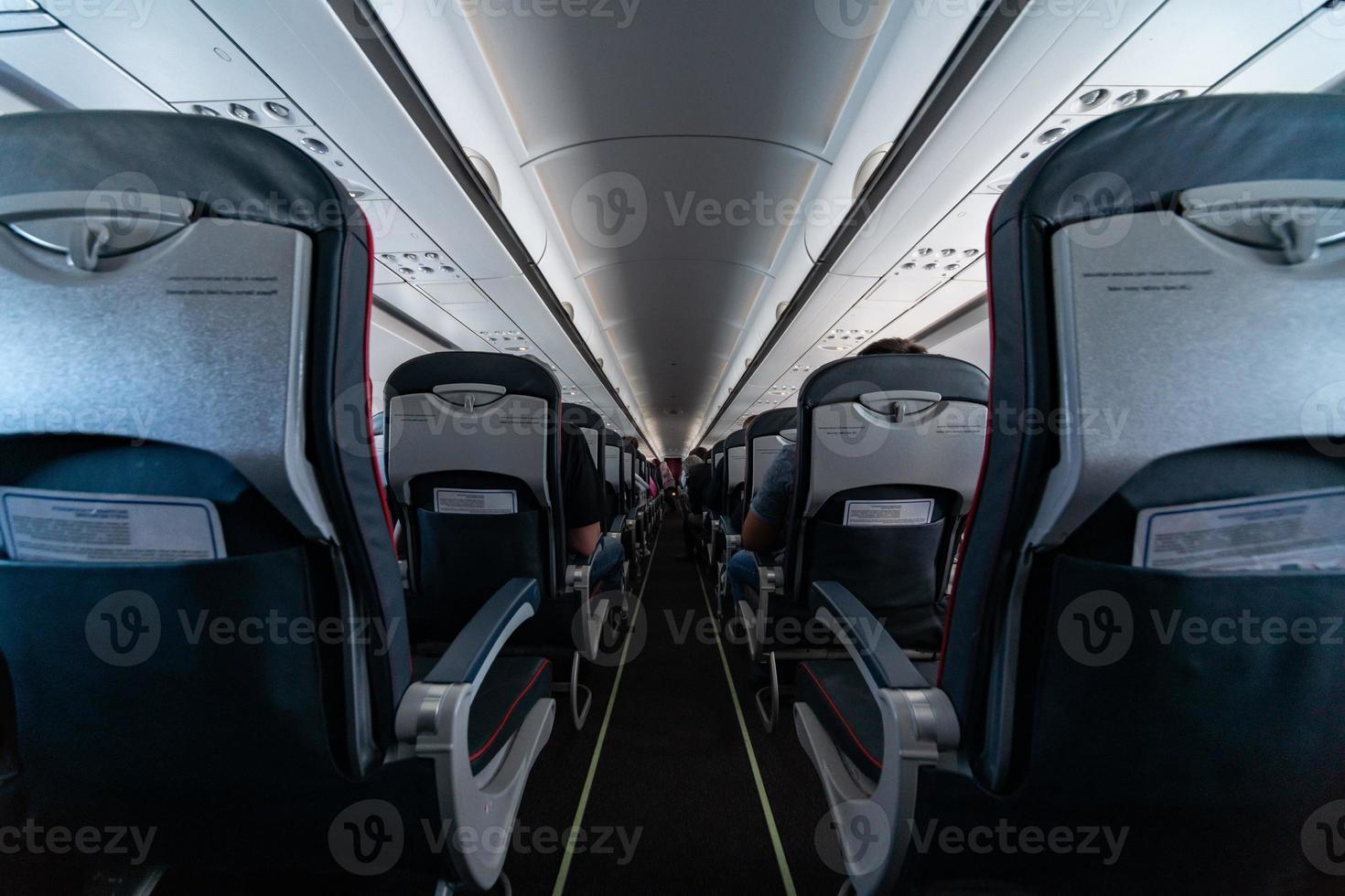 Airplane cabin seats with passengers. Economy class of new cheapest low-cost airlines without delay or cancellation of flight. Travel trip to another country. photo