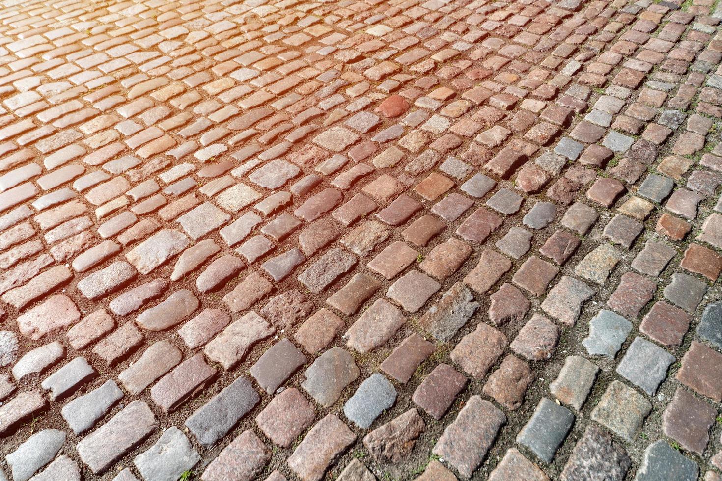 antiguo patrón de adoquines. textura de adoquines alemanes antiguos en el centro de la ciudad. pequeños azulejos de granito. pavimentos grises antiguos. foto